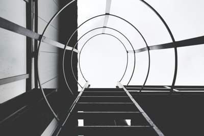 black and white shot of a set of stairs going up through a tunnel